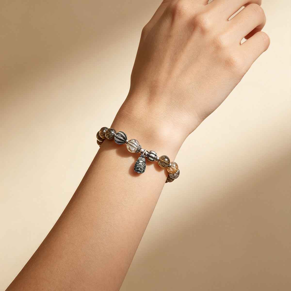 Beaded wealth bracelet on wrist with dark and silver-tone charm beads