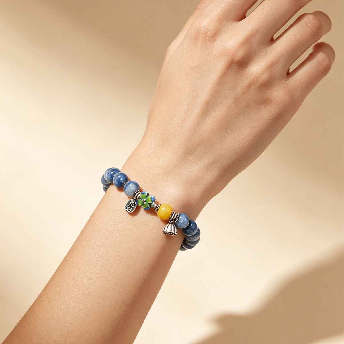 Beaded kyanite-style bracelet with blue stones, yellow accent, and charm drops