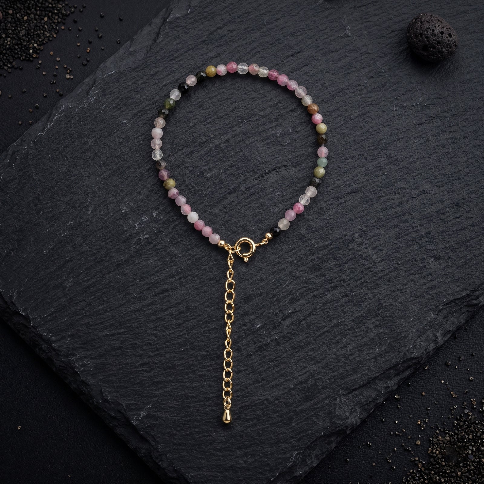 Beaded crystal bracelet with pastel pink and green stones; gold clasp and long chain