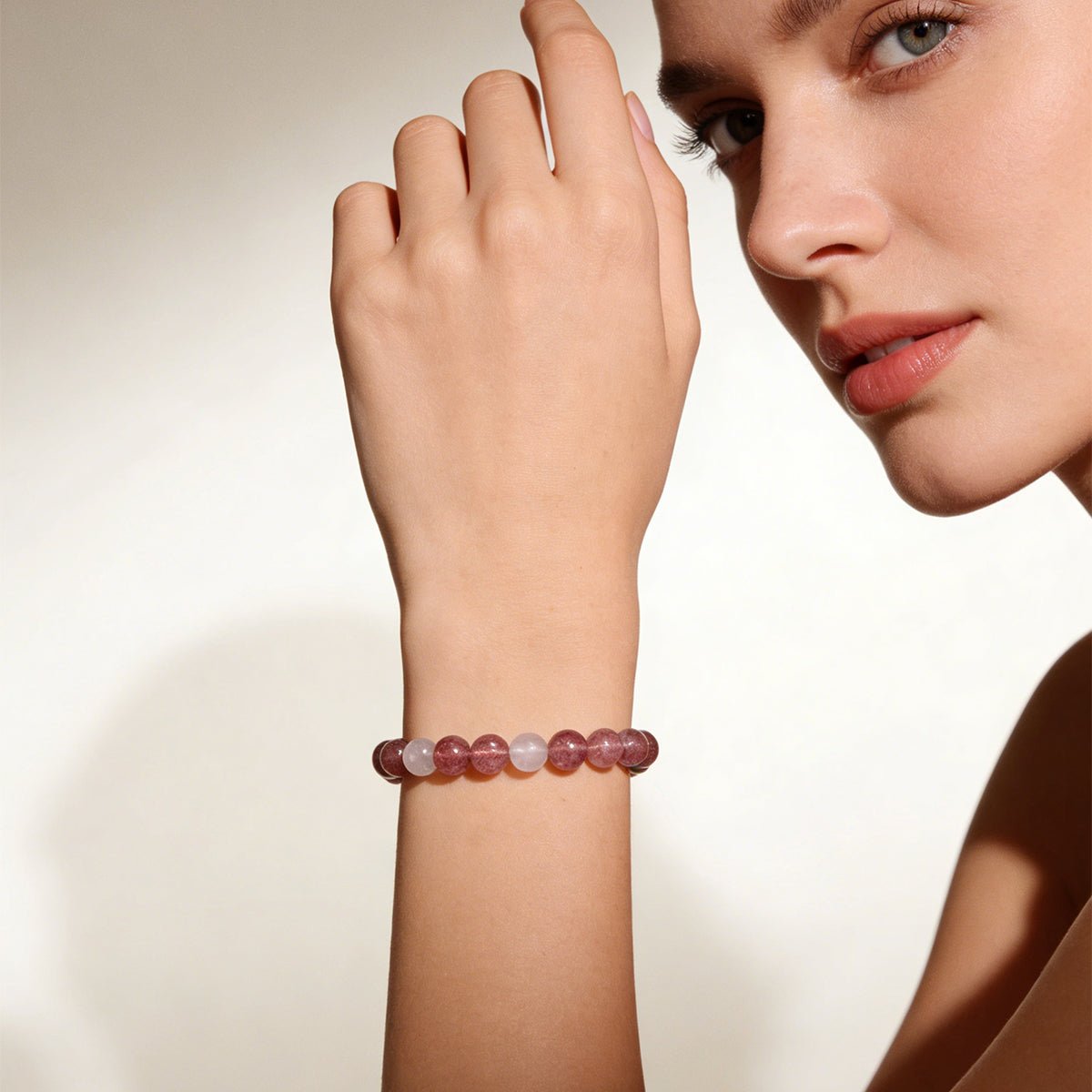 Beaded love bracelet on model’s wrist with pale pink and clear round stones