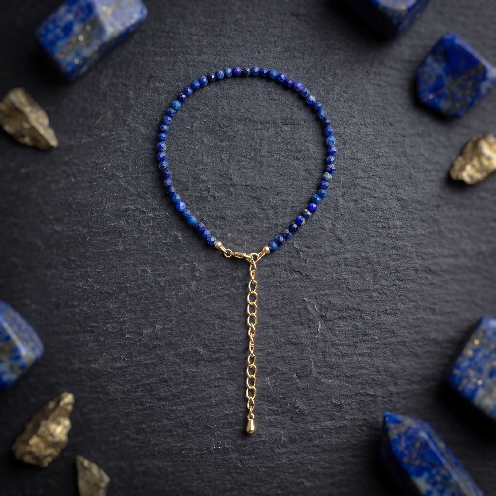 Blue lapis lazuli beaded bracelet with gold-tone chain drop and clasp