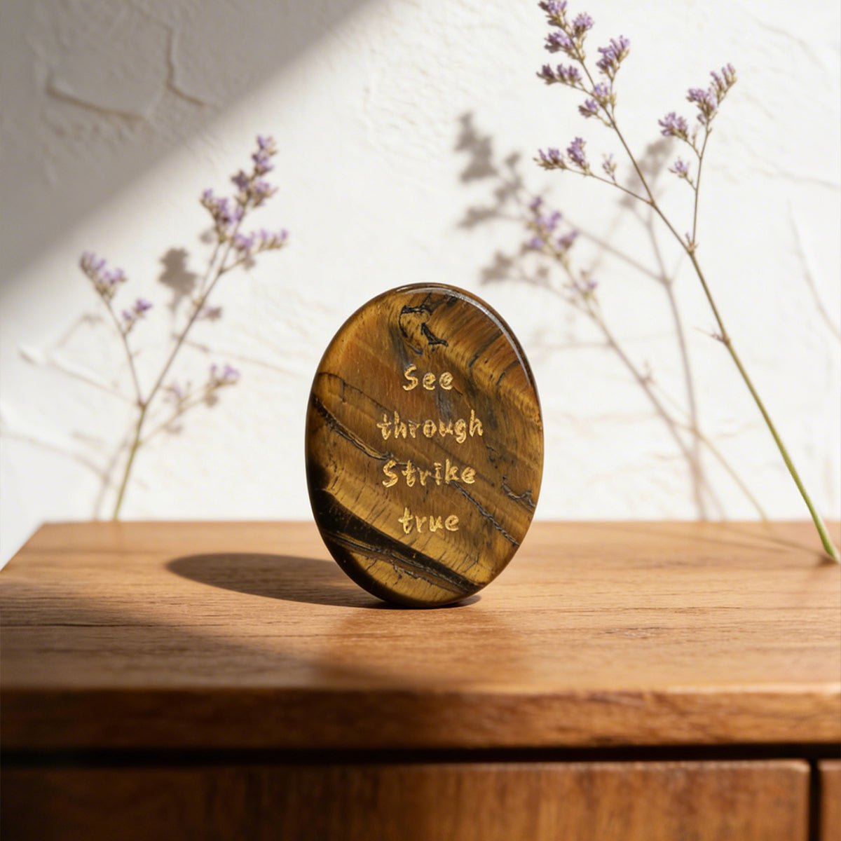 Oval tiger’s eye stone with engraved words, polished gold-brown finish