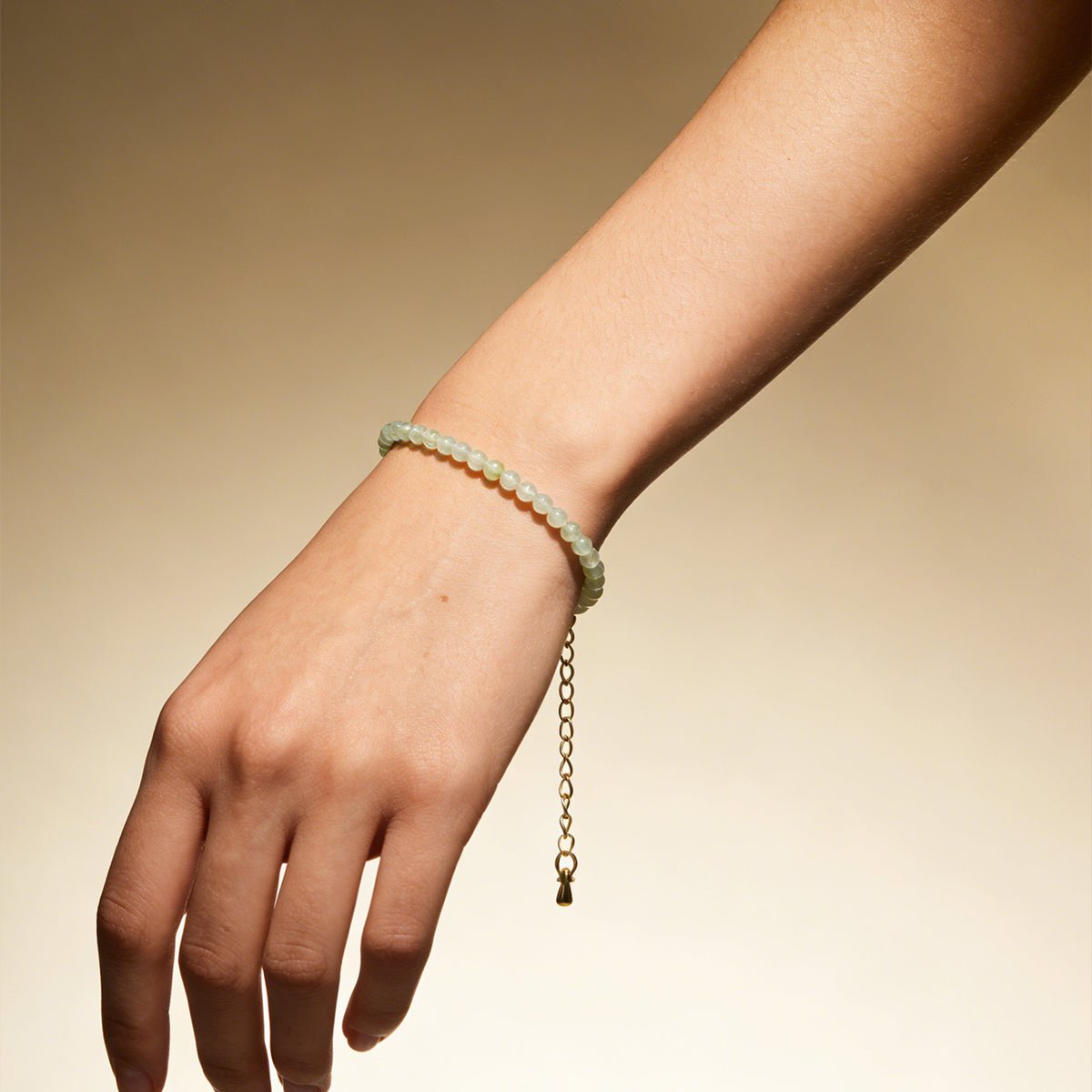 Aqua bead crystal bracelet with gold chain tassel charm on hand