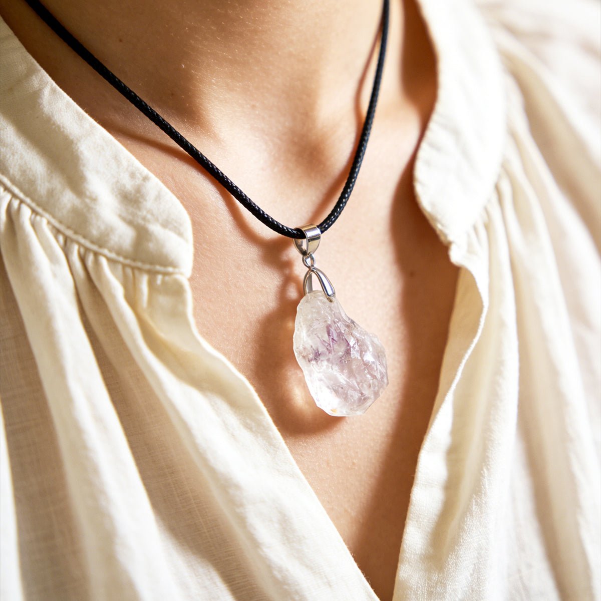 Faceted clear quartz pendant on black cord necklace with silver bail