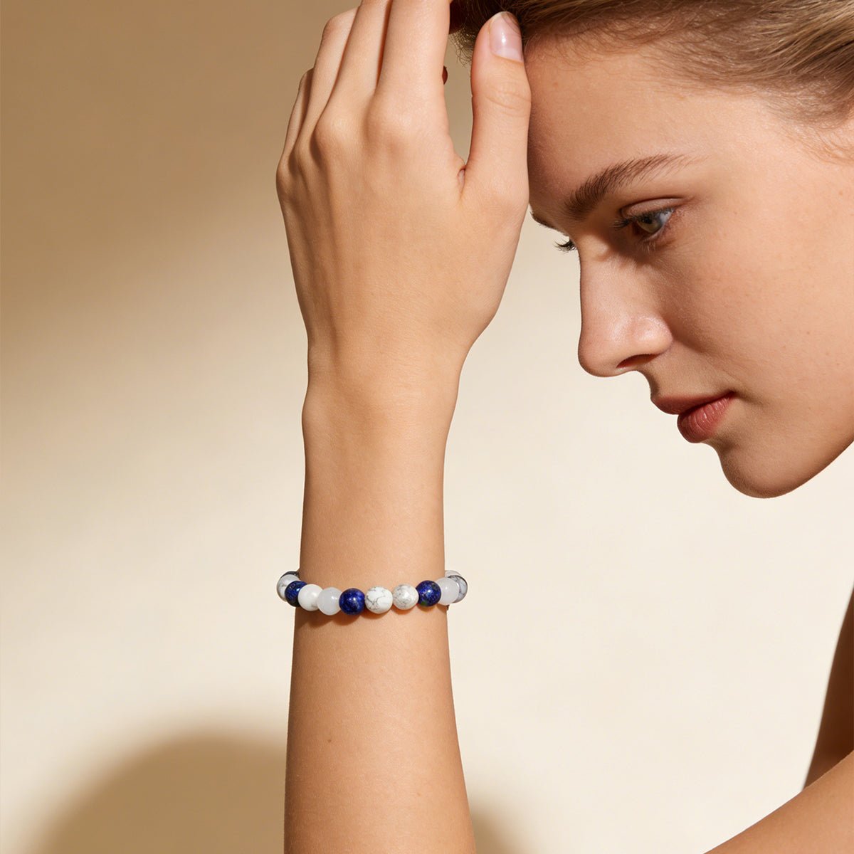 Crystal beaded bracelet on arm with white and dark blue round stones