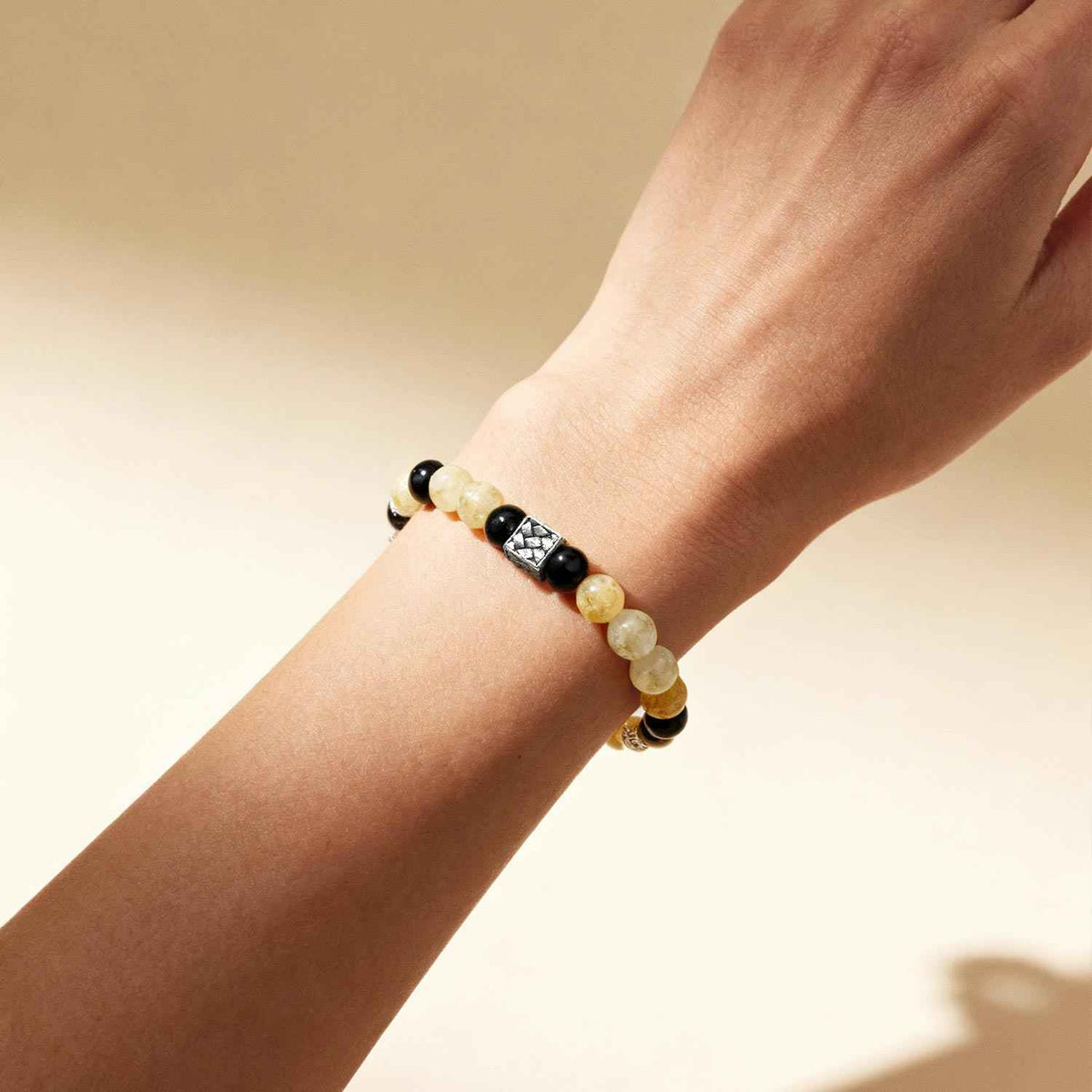 Crystal bracelet on wrist with cream and black beads and silver spacers