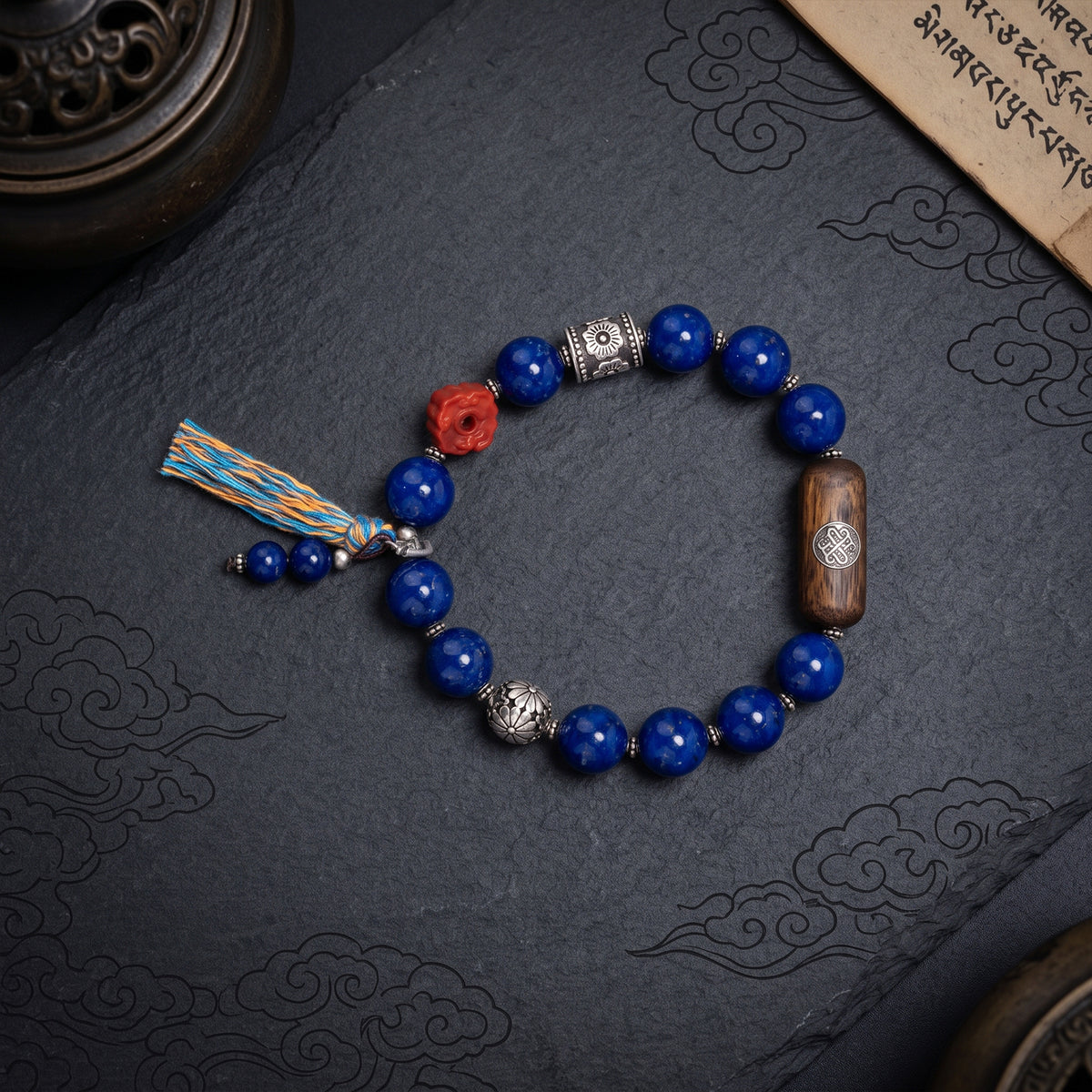 Tibetan lapis lazuli bracelet with round blue beads, silver accents, and red carved charm