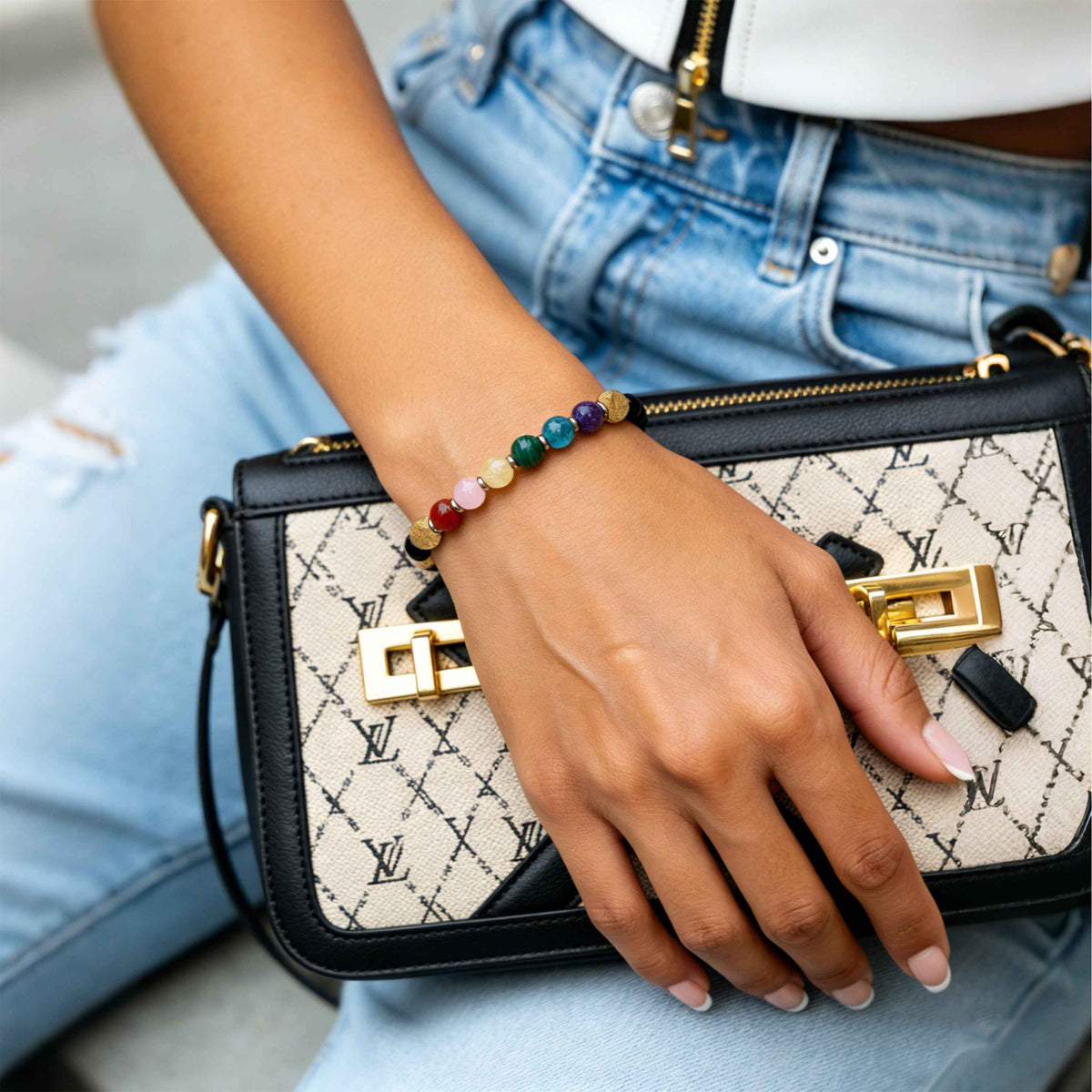 Hand-worn crystal bracelet with black beads and colorful gemstone accents