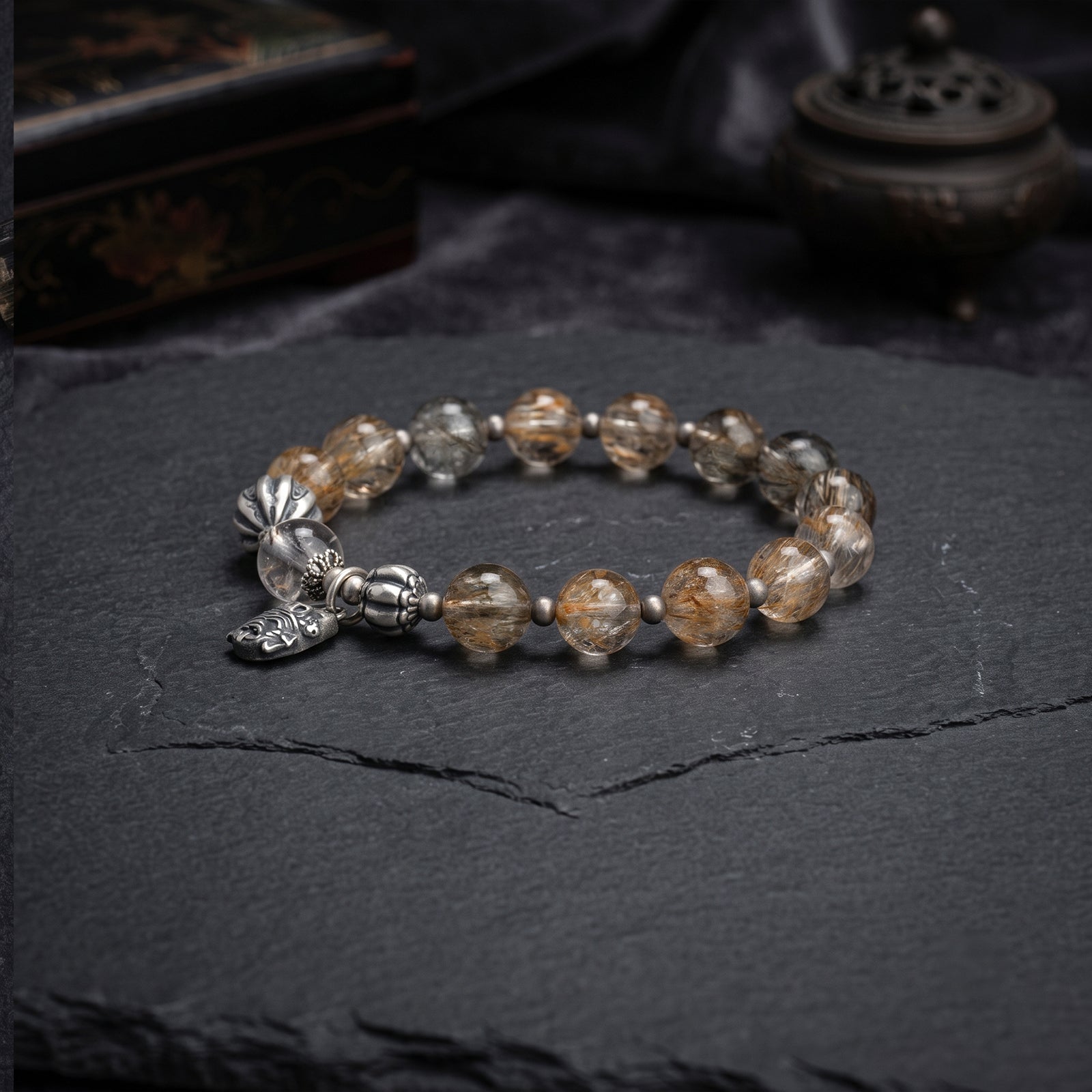 Beaded wealth bracelet with golden-brown stone beads and silver-toned charms