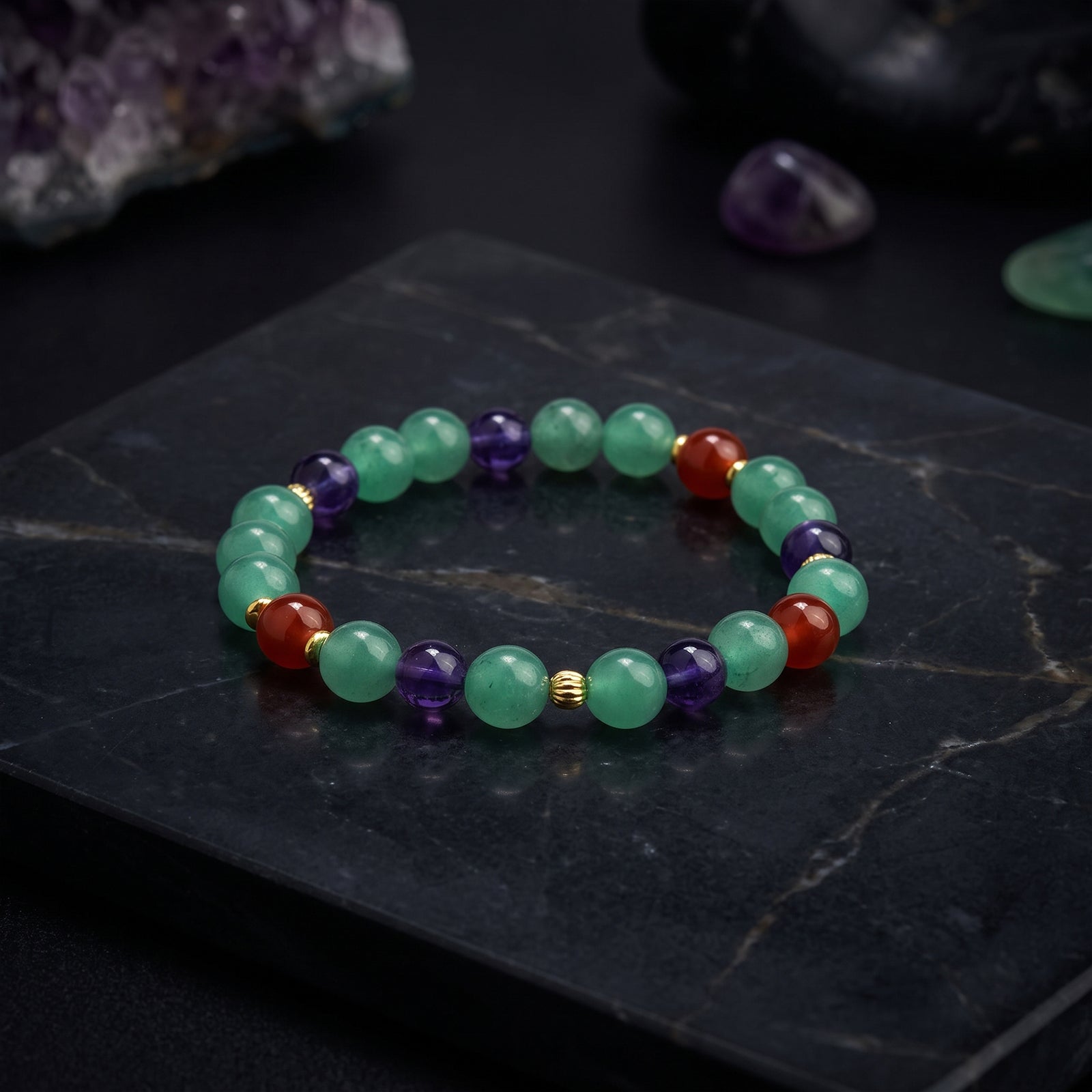 Gemstone beaded bracelet with green and purple round beads, red accents, gold spacers