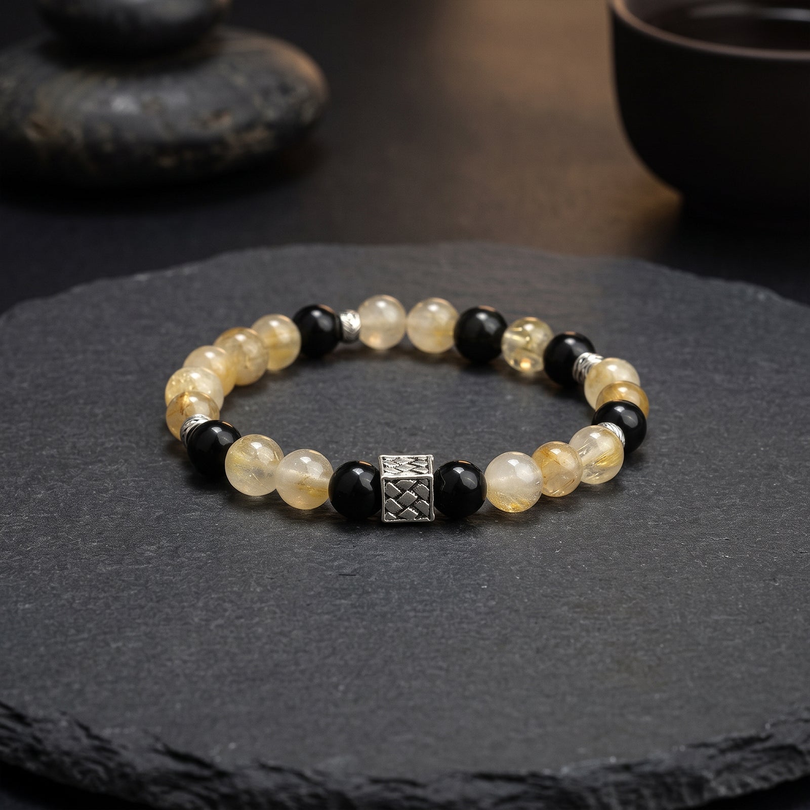 Beaded chakra bracelet with pale yellow and black beads, silver square charm centerpiece