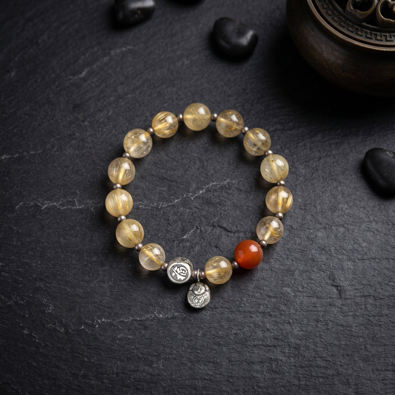 Golden rutilated quartz bead bracelet with red center bead and silver charm