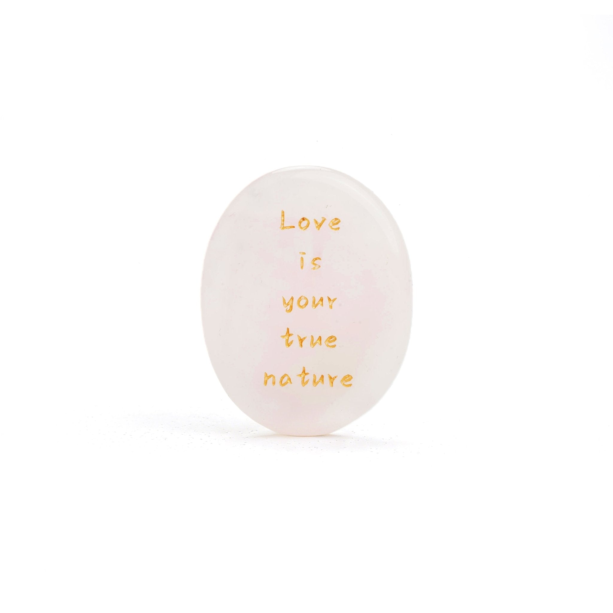 Rose quartz oval stone with gold text reading Love is your true nature