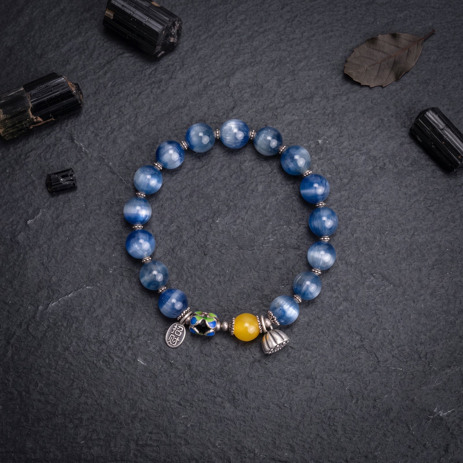 Blue round stone bracelet with silver charms and multicolor bead accents