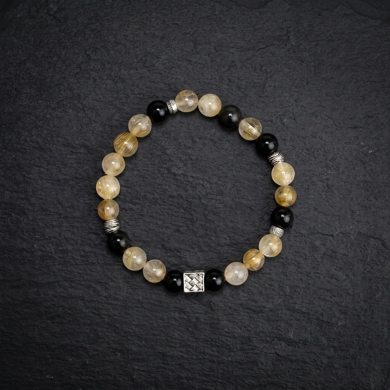 Beaded chakra bracelet with pale yellow beads, black accents, silver coil spacers and square charm
