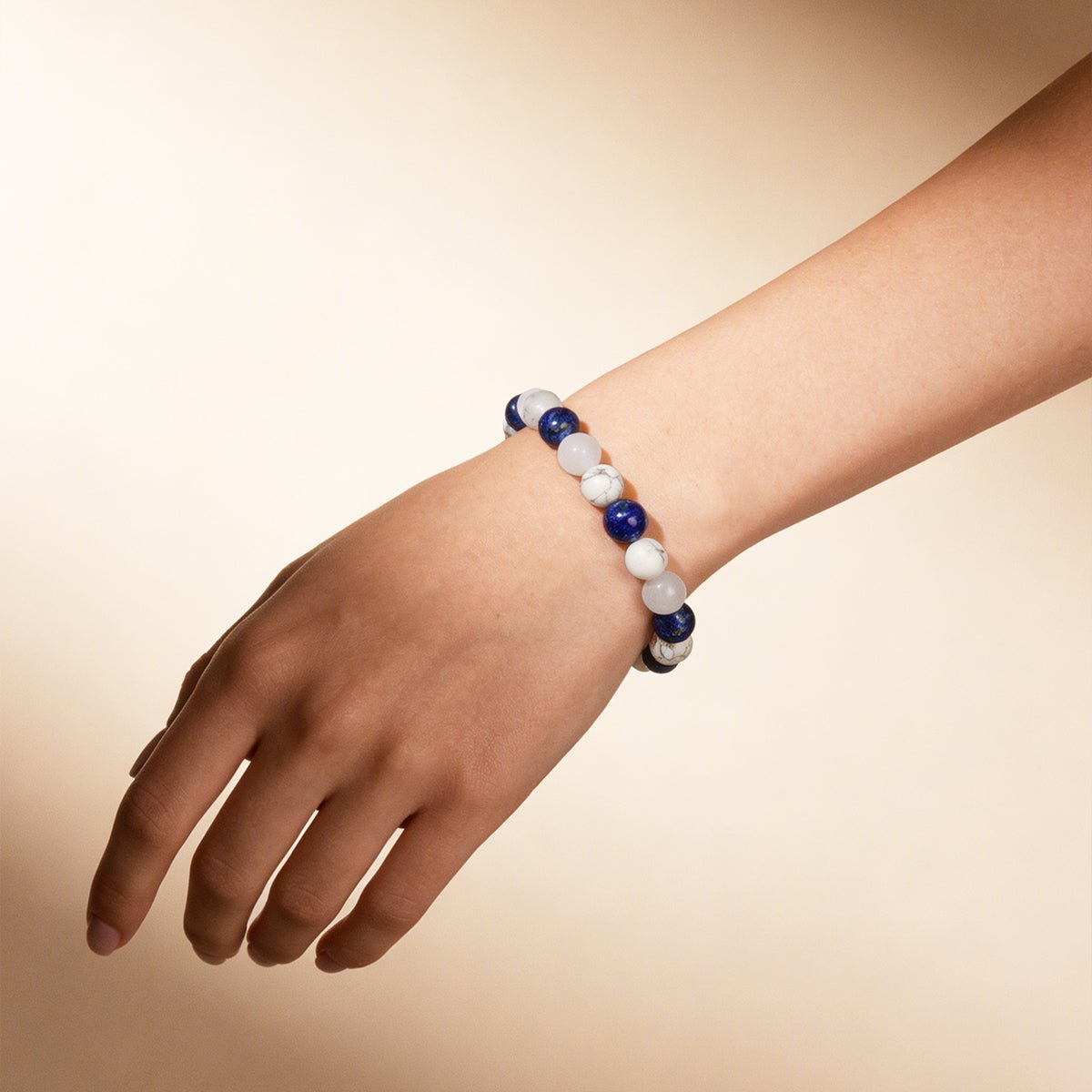 Crystal beaded bracelet on wrist with white and dark blue bead strand