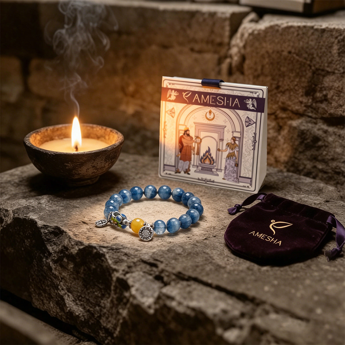 Amesha Energy blue crystal bracelet displayed on stone next to a lit candle, brand pouch, and Zoroastrian sacred fire card.