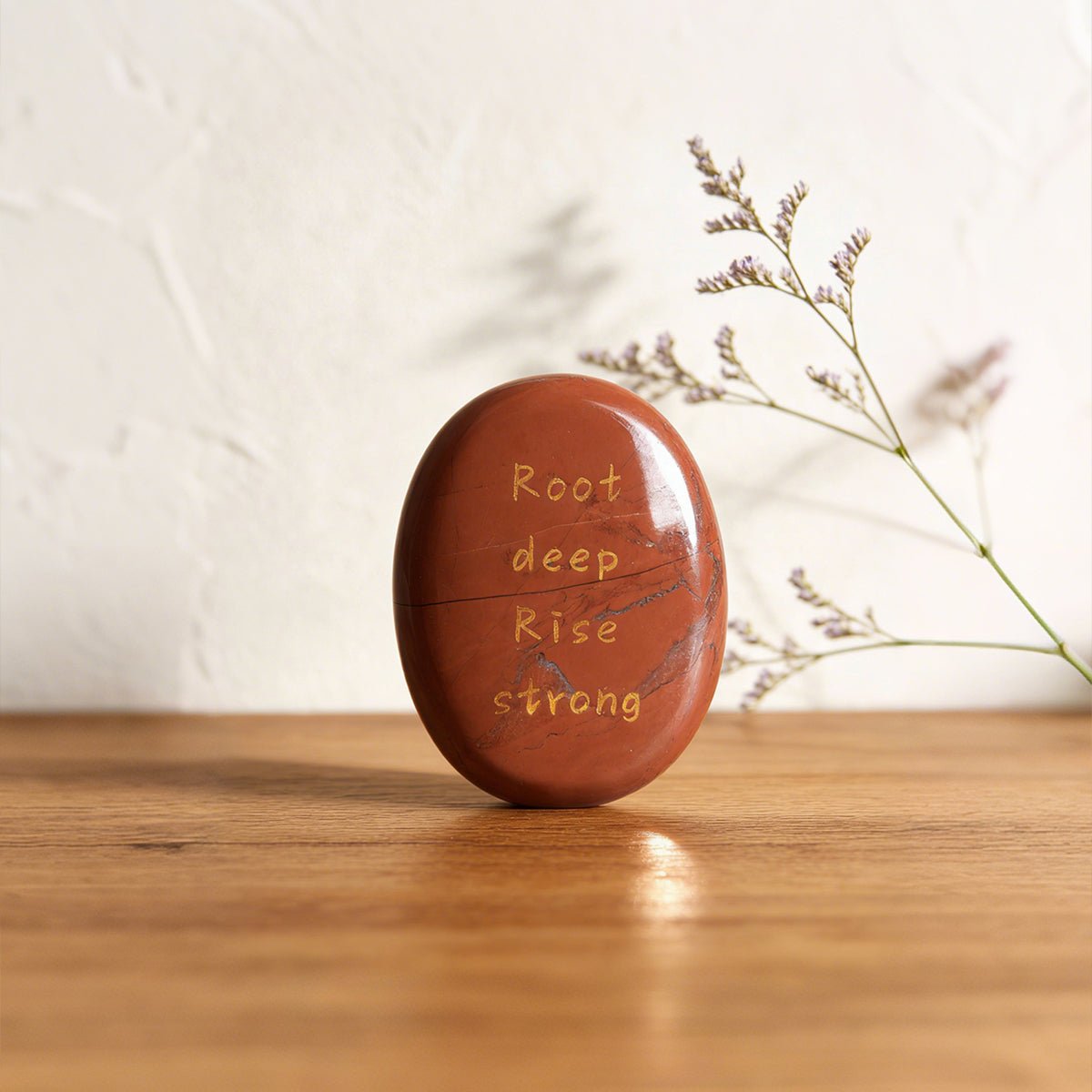 Red jasper oval stone with carved words Root deep Rise strong