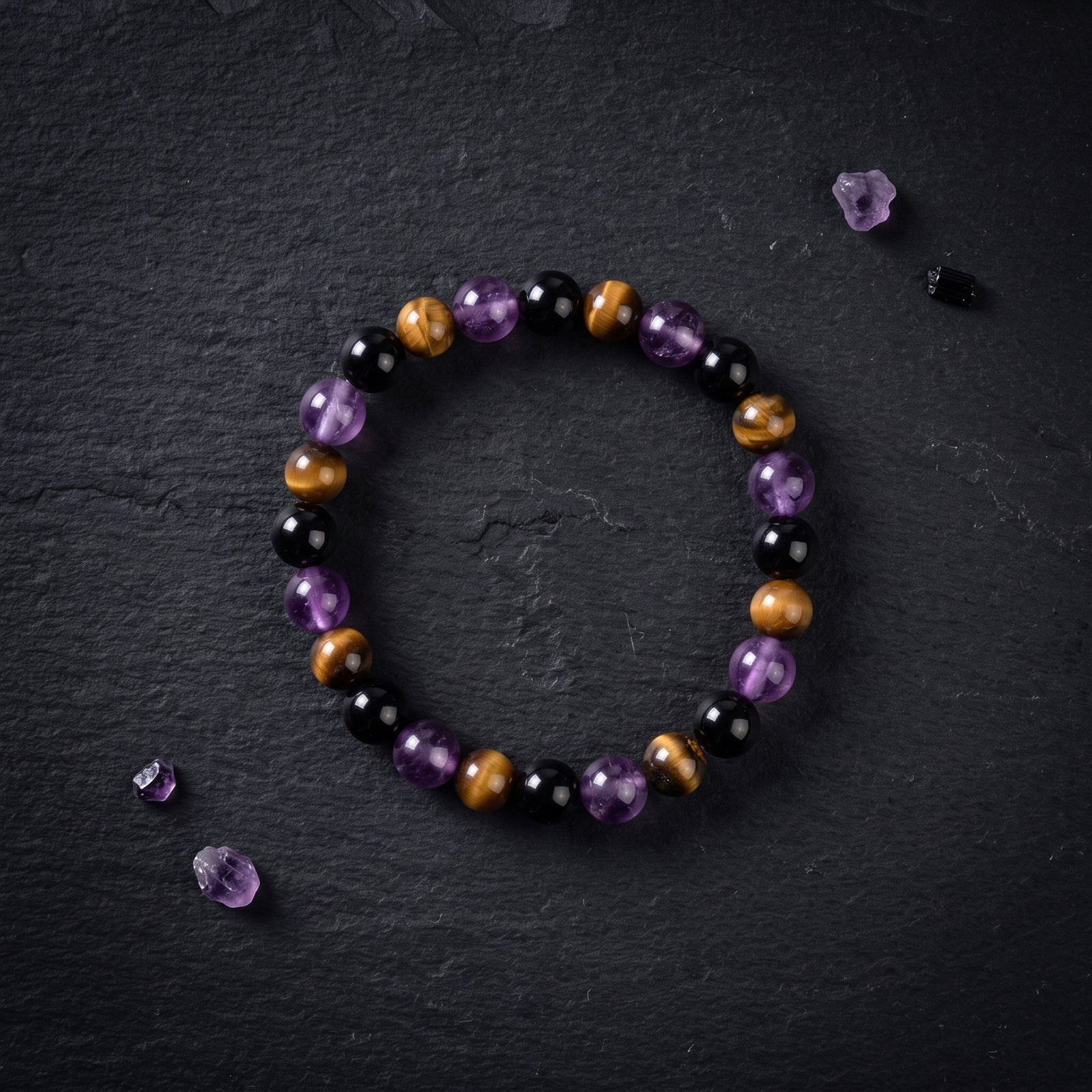 Crystal bead bracelet, circular view: purple, black, and bronze-toned round beads