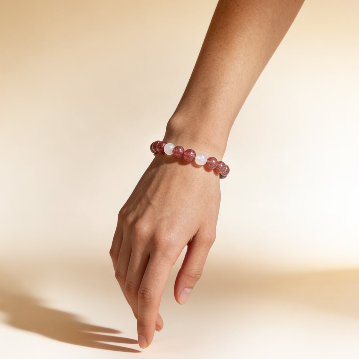 Beaded love bracelet on wrist with pale pink and clear round stones