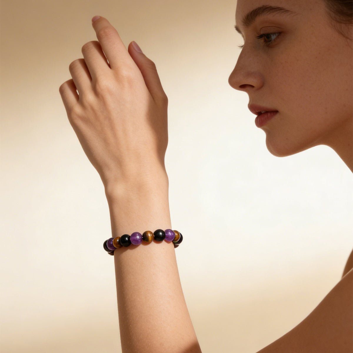 Crystal bead bracelet on arm with black and purple stones and brown accents