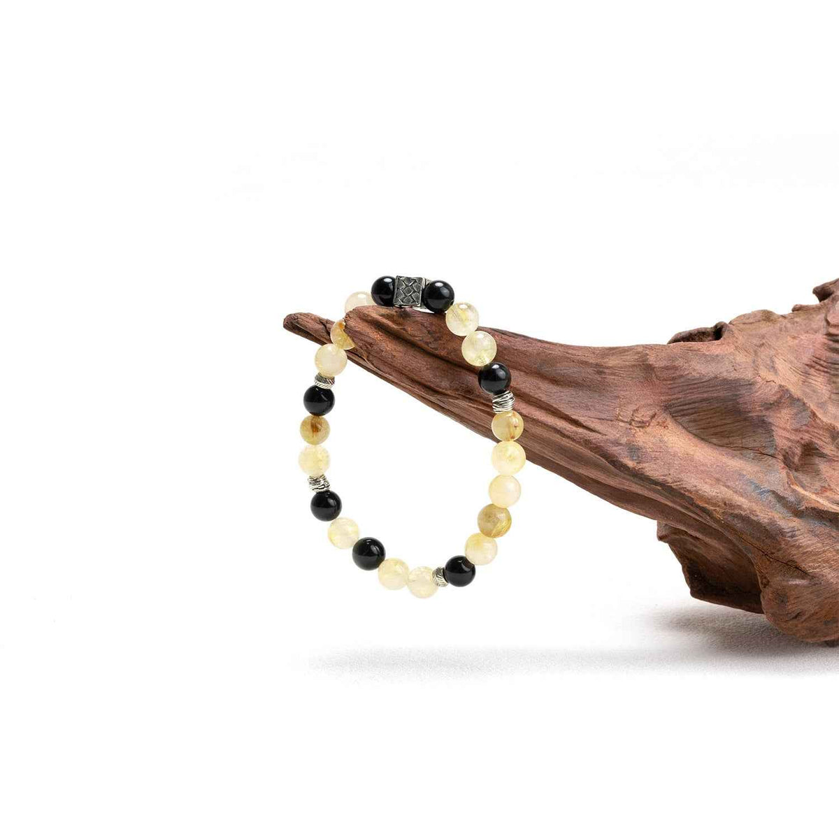 Crystal bracelet with cream and black beads and silver accents, resting on wood