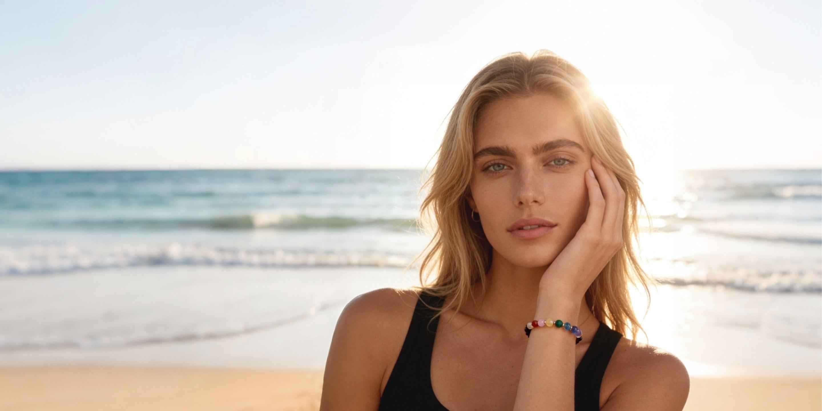 Amesha Energy 7 Chakra Healing Crystal Bracelet - Woman wearing multi-colored natural gemstone jewelry at the beach for balance