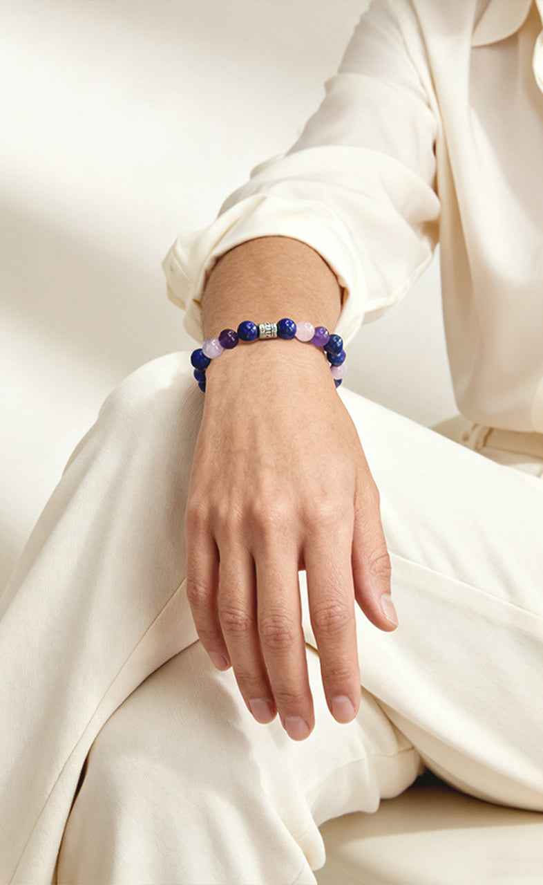 Closeup on wrist wearing Amesha Energy Ajna Chakra Clarity Crystal Bracelet - Natural Lapis Lazuli and Amethyst beads for boosting intuition