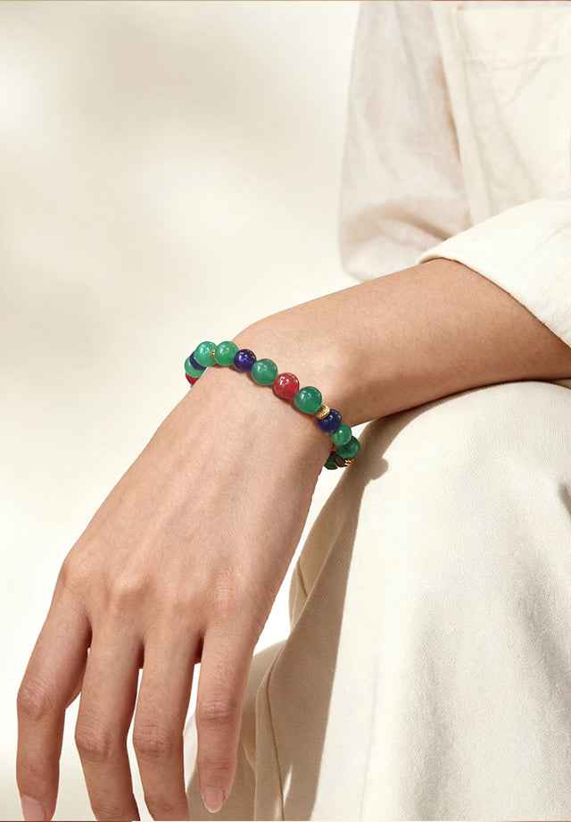 Woman wearing Amesha Energy Heart Chakra Healing Crystal Bracelet - Green gemstones and Amethyst beads for attracting love and balance