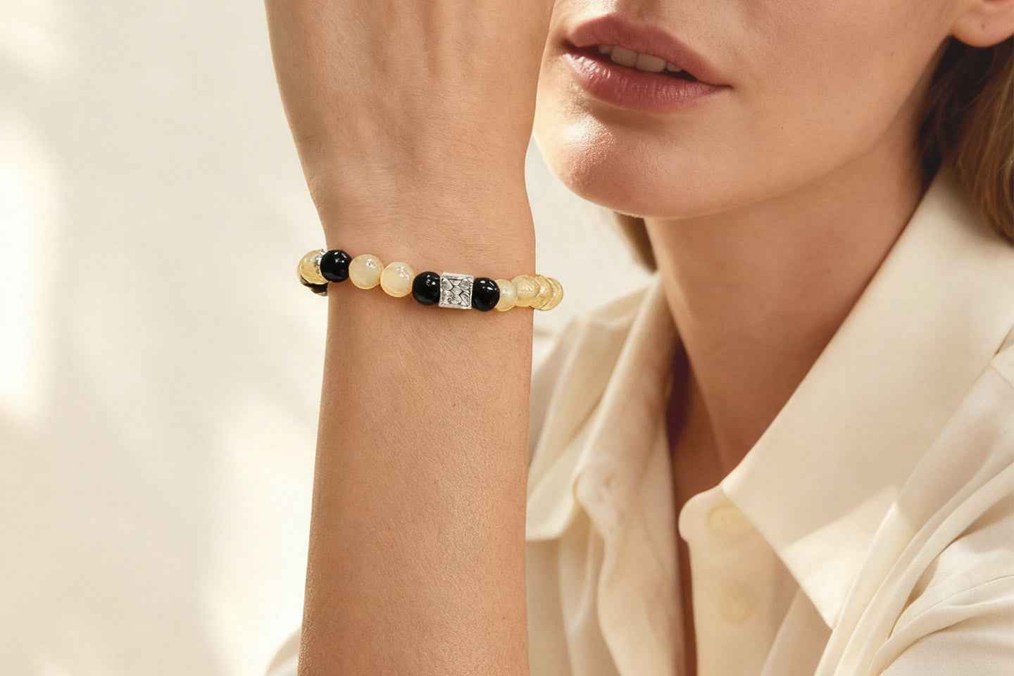 Woman wearing Amesha Energy Root Chakra Guardian Crystal Bracelet - Natural Obsidian and Snowflake Obsidian beads for protection and stability