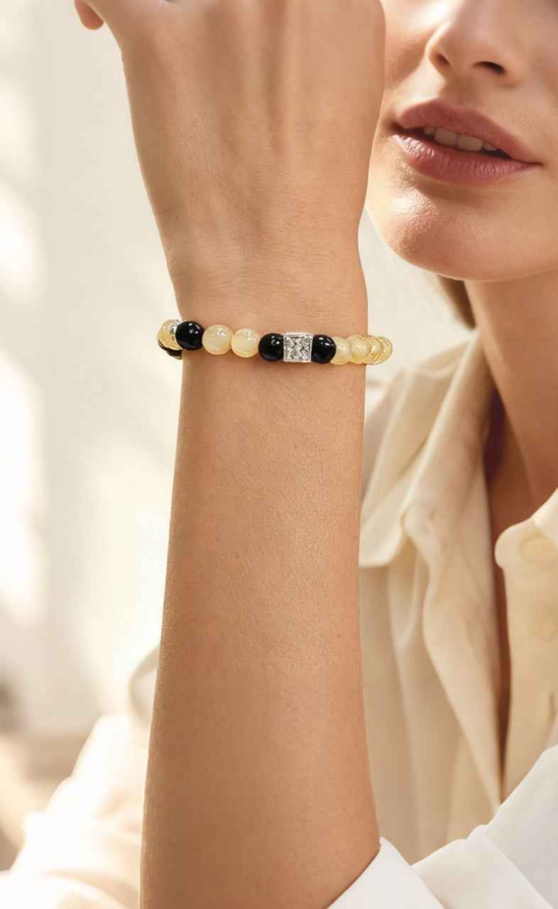 Closeup of wrist wearing Amesha Energy Solar Plexus Chakra Bracelet - Yellow and black beads for boosting confidence