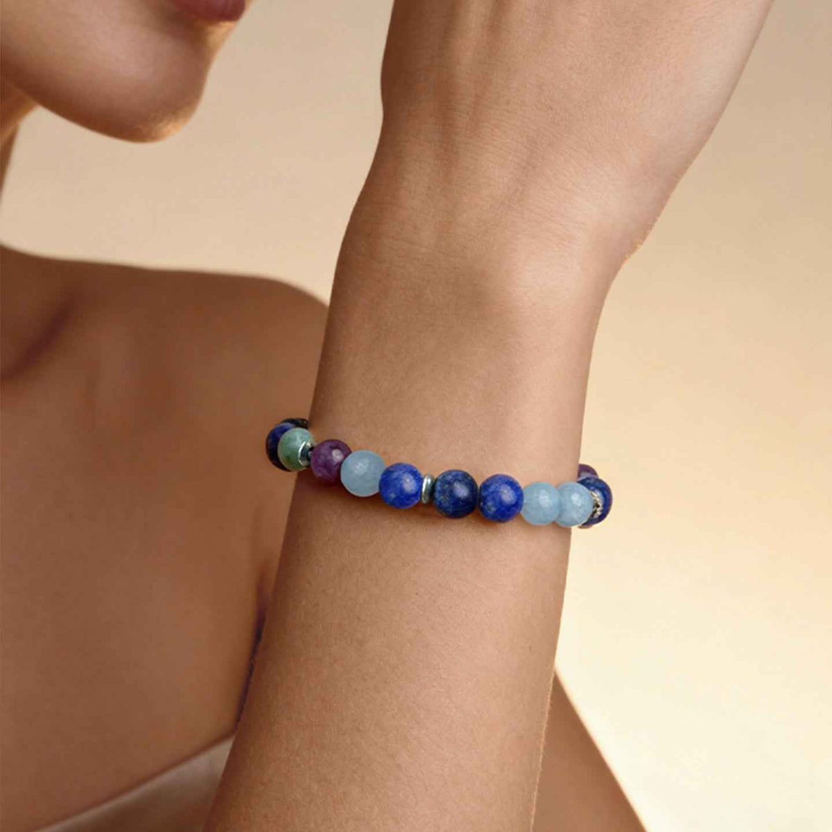 Closeup of wrist wearing Amesha Energy Throat Chakra Truth Crystal Bracelet - Blue Labradorite and mixed gemstone beads for self-expression