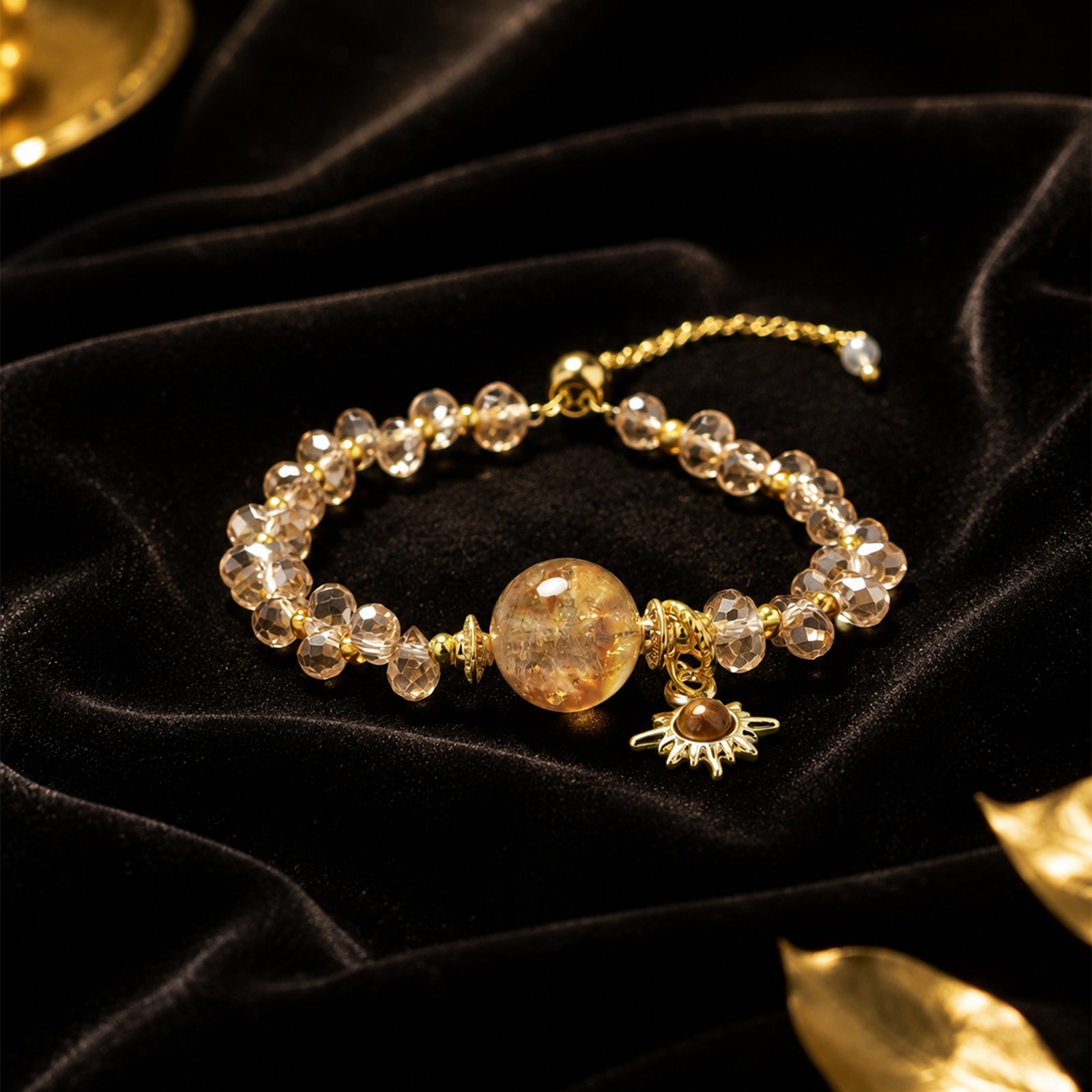 Gold-tone beaded pendant bracelet with amber round center and sun charm