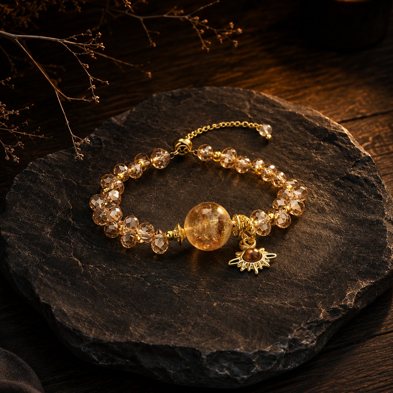 Gold-tone crystal bead bracelet with round amber focal bead and sun charm