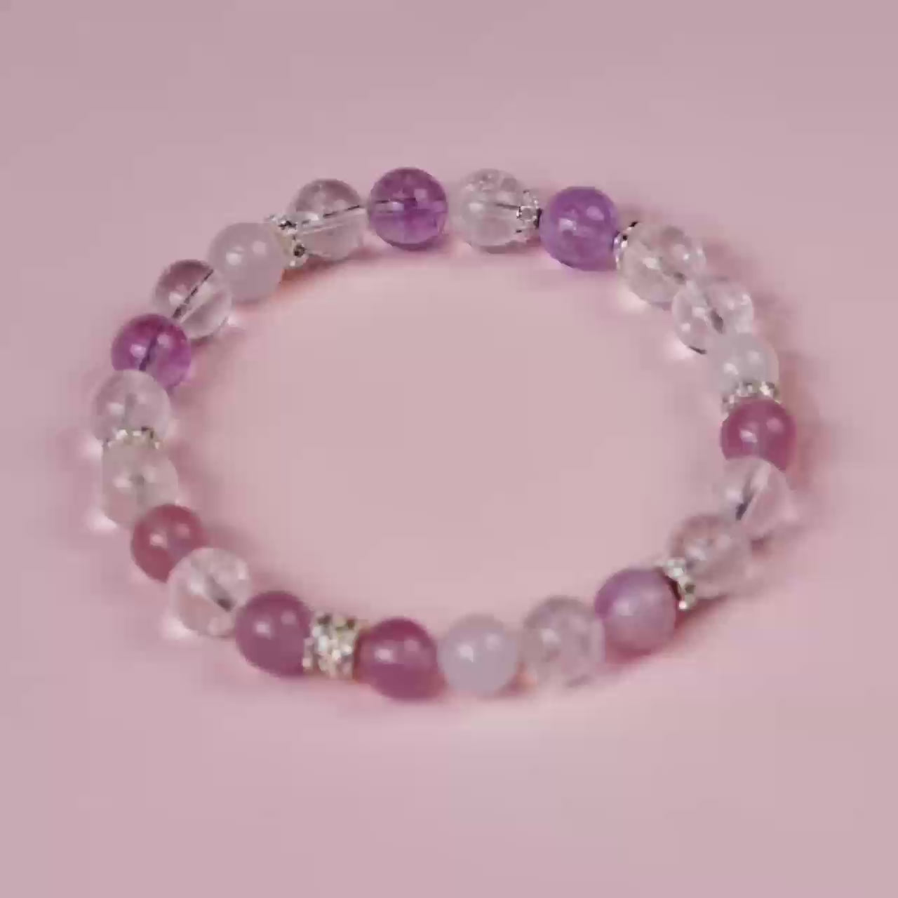 A close-up video of a handmade 7 chakra balancing bracelet featuring Amethyst and Rose Quartz, an ideal meaningful gift for spiritual wellness and love.